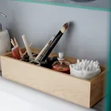 Large, elegant bathroom with dark colors, stylish mirror cabinet with integrated lighting, and luxurious stone countertop.