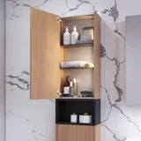 Bathroom inspiration with washbasin cabinets and wall cabinets in light oak with grooves, elegant double sink, beautiful mirror cabinet with light, herringbone floor in light wood, and white marble wall give a classic, bright, and sleek look.