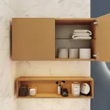 Small stylish bathroom with dark blue walls, soft yellow bathroom furniture with grooves, and an elegant round mirror with lamp