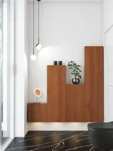 Modern and stylish bathroom inspiration with an oval mirror with a black frame and light control, colored toilet, vanity unit, base cabinets, and cabinets in reddish-brown oak, Silestone sink and matching floor