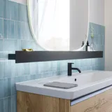 Bathroom inspiration with elongated blue tiles, natural oak bathroom furniture with black details, creating a harmonious and sophisticated look