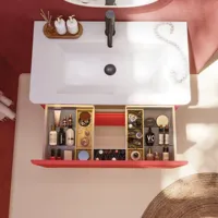 Bathroom inspiration with red walls, softly shaped red vanity and tall cabinet, elegant white sink and beautiful oval mirror with light, creating a vintage look together with the natural surroundings