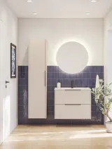 Bathroom inspiration with elongated blue tiles, elegant beige vanity unit and tall cabinet with black, minimalist and elongated handles and a round mirror with light for a beautiful and contrasting look.